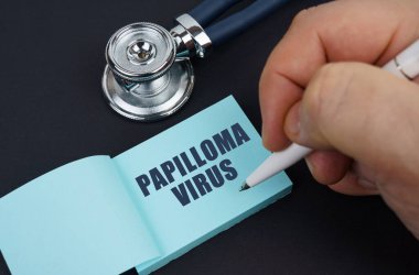 Tıp ve sağlık konsepti. Siyah bir masada steteskop ve adamın PAPILLOMA VIRUS 'u yazdığı bir defter var.