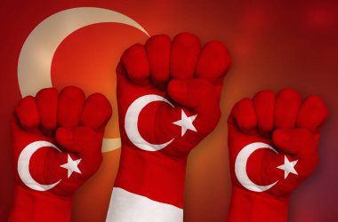 Türkiye bayrağı sıkılmış bir yumruk ve arka planda çekiliyor. Protesto, güç ve güç kavramı.