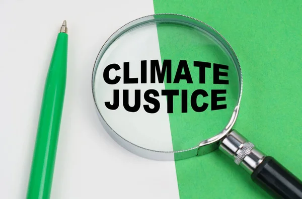 生态概念 在白绿的背景上 有一支钢笔和一个放大镜 里面刻着 气候公正 — 图库照片