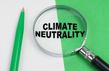 Ekolojik kavram. Beyaz-yeşil bir arka planda bir kalem ve bir büyüteç bulunur, içinde bir yazı vardır - iklim tarafsızlığı.