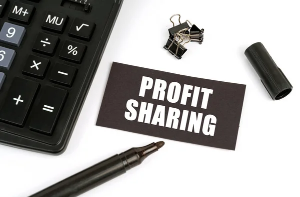 İş ve finans kavramı. Beyaz bir masanın üzerinde bir hesap makinesi, bir işaret ve üzerinde 