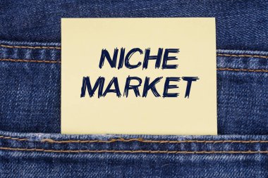 Ekonomi ve eğitim kavramı. Üstünde Niche Market yazan bir kotun cebinden çıkan bir kağıt var.