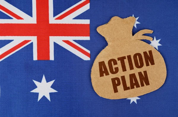 A zászló Ausztrália fekszik egy karton figura egy pénzeszsák a felirat - cselekvési terv — Stock Fotó