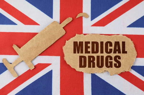 영국의 국기에 새겨진, 의료용 약품이 들어 있는 주사기와 판지 모양 — 스톡 사진