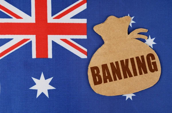 A zászló Ausztrália fekszik egy karton figura egy pénzeszsák a felirat - bank — Stock Fotó