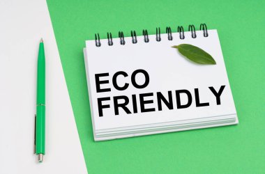 Beyaz-yeşil arka planda bir kalem, bir bitki yaprağı ve yazılı bir not defteri bulunur - ECO ARKADAŞI