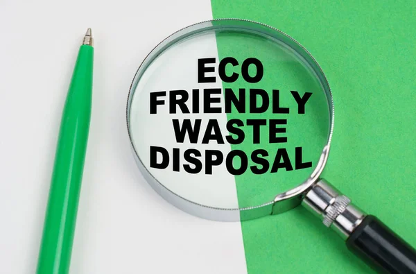Na bílo-zeleném pozadí leží pero a lupa s nápisem - Ekologická likvidace odpadů — Stock fotografie