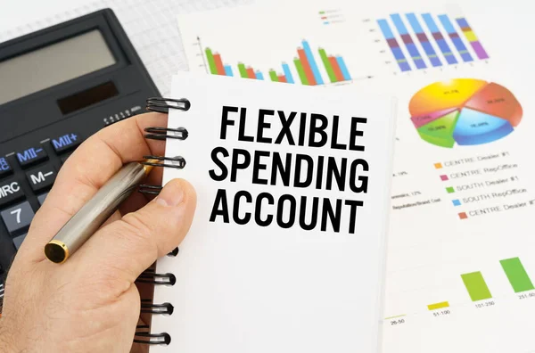 The man is holding a pen and a notebook with the inscription - FLEXIBLE SPENDING ACCOUNT — Stock Photo, Image