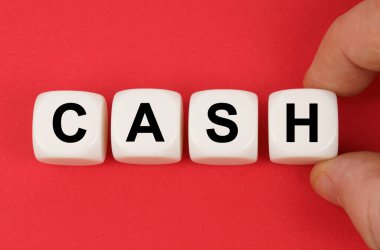 Kırmızı yüzeyde, üzerinde para yazan beyaz küpler.