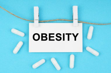 Tıbbi konsept. Mavi bir yüzeyde, raptiyeli bir iple, beyaz bir plaka var.