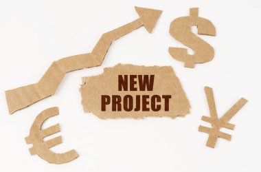 Ekonomik konsept. Beyaz arkaplanda dolar, avro, yen sembolleri, yukarı bakan bir ok ve üzerinde yazı olan yırtık bir karton - NEW PROJECT