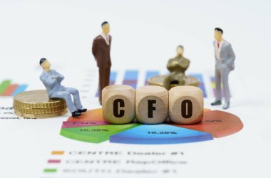İş ve finans kavramı. Diyagramlı mali raporlar, iş adamlarının rakamları ve üzerinde CFO yazan tahta küpler.