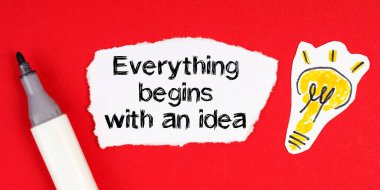 İş konsepti ve fikri. Kırmızı bir yüzeyde bir işaret, bir ampul çizimi ve üzerinde 