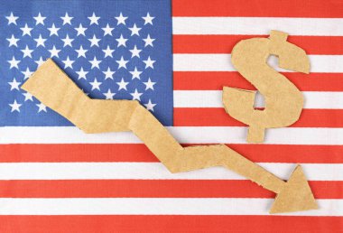 İstatistik konseptini azalt. Amerikan bayrağında bir dolar sembolü ve aşağıya bakan bir ok var..