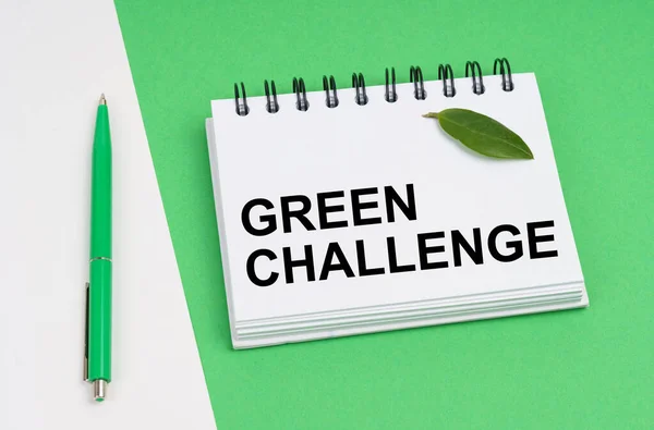 生态概念 在白绿色的背景上 有一支笔和一个记事本 上面有题词 绿色的挑战 笔记本上有植物的绿叶 — 图库照片