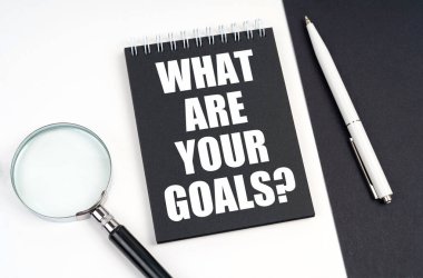 İş ve ekonomi kavramı. Siyah ve beyaz bir yüzeyde bir büyüteç, bir kalem ve üzerinde 