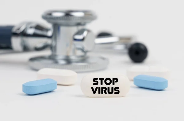 医学と健康の概念 白い表面の嘘の丸薬 聴診器 碑文付きのタブレットで Stop Virus — ストック写真