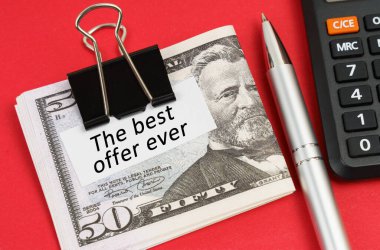 İş ve ekonomi kavramı. Kırmızı bir yüzeyde bir hesap makinesi, bir kalem ve dolar bulunur. Dolarlar, üzerinde 