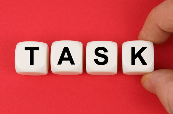 Business and finance. On the red surface, white cubes with the inscription - TASK