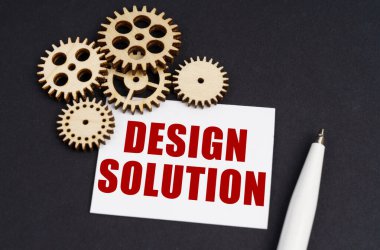 Sanayi konsepti. Siyah yüzeyde dişliler, bir kalem ve yazılı bir kartvizit var. Tasarım çözümü.