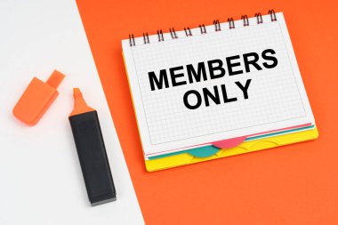 İş ve finans kavramı. Beyaz-turuncu bir yüzeyde bir işaret ve üzerinde sadece Üyeler yazan bir not defteri bulunur.