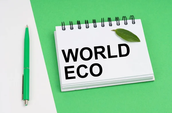生態学的概念 白い緑の背景にペンと碑文とノートパッドがあります World Eco ノートに植物の緑の葉があります — ストック写真