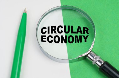 Ekolojik kavram. Beyaz-yeşil arka planda bir kalem ve bir büyüteç var, içinde de yuvarlak ekonomi yazılı.