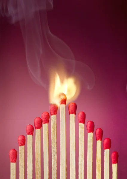 Burning match setting fire to its neighbors — Stock Photo, Image