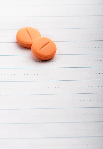 Two pills on lined paper — Stock Photo, Image