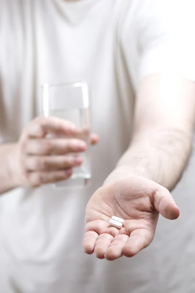Cuidar do homem trazendo pílula e água — Fotografia de Stock