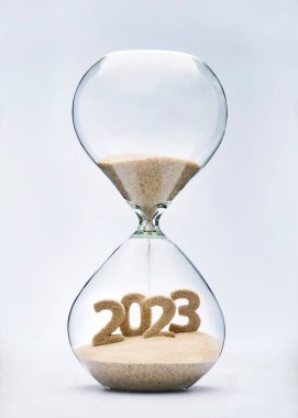 New Year 2023 concept with hourglass falling sand taking the shape of a 2023