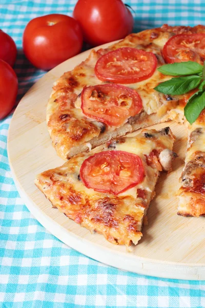 Tasty vegetarian pizza with cheese, tomatoes and mushrooms on a wooden board — Stock Photo, Image