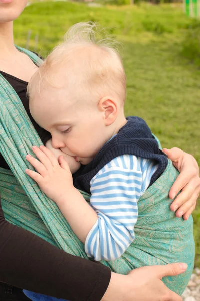 Breastfeeding in baby sling outdoors — Stock Photo, Image