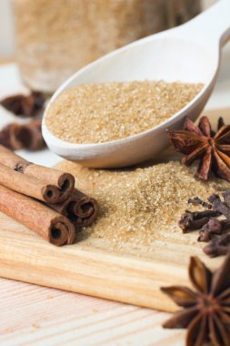 esmer şeker, tarçın, yıldız anason ve karanfil tahta kaşıkla