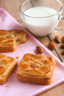 Bademli bisküvi portre üzerinde bir fincan süt ahşap rustik masa üstünde pembe masa örtüsü