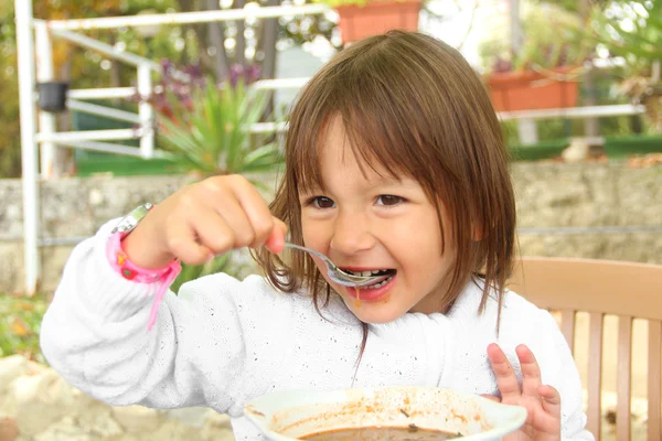 Little girl eating vegetarian soup outdoors in summer — Stock Photo, Image