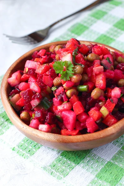 Russian beetroot salad Vinaigrette in wooden bowl on green and white tableclothes with a fork — Stock Photo, Image