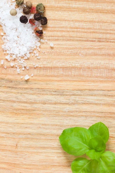 Holzstruktur Hintergrund mit frischen Basilikumblättern, Salzkristallen und Paprika — Stockfoto
