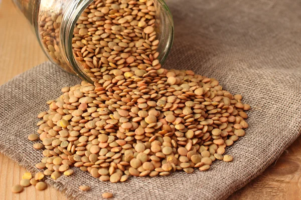 Green lentils on linen sackcloth — Stock Photo, Image