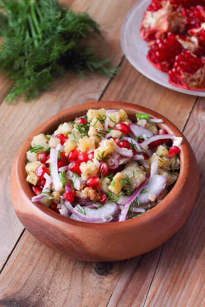 Insalata di semi di melograno orientale con patate, aneto e noci sul tavolo di legno — Foto Stock