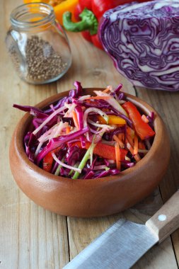 Şef bıçağı ve kişniş ile tahta masada biber kırmızı lahana salatası