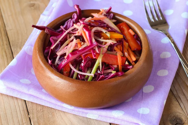 Красный салат из капусты на фиолетовой салфетке с вилкой — стоковое фото