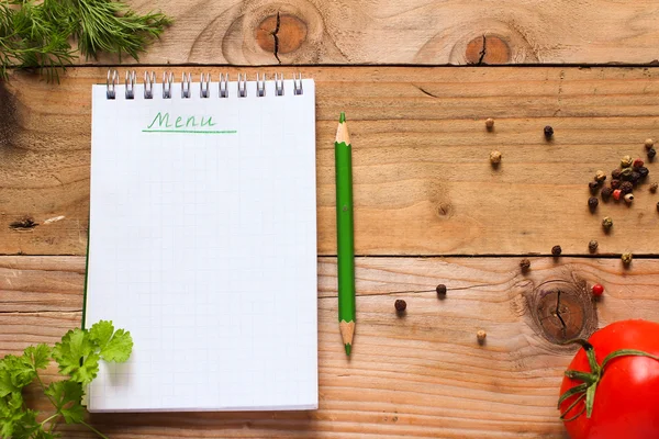 Notebook for recipes with green pencil, fresh herbs, spices and tomato on old wooden table — Stock Photo, Image