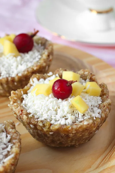 Healthy sweets. Vegan raw cupcakes with nuts, fruits and coconut shavings — Stock Photo, Image