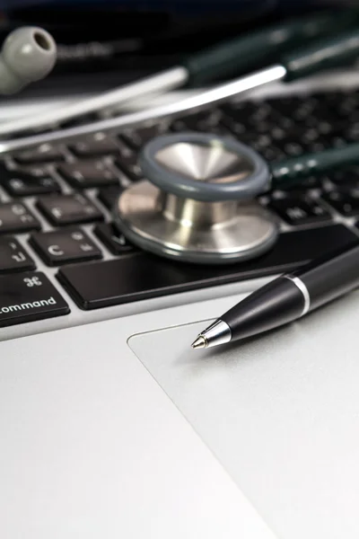 Pen and stethoscope on keyboard laptop — Stock Photo, Image