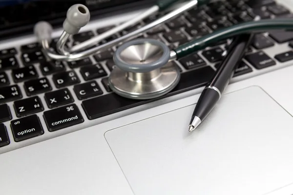 Penna och stetoskop på tangentbord laptop — Stockfoto