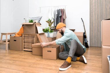 Yetişkin adam yeni mobilyasız dairelere taşınıyor.