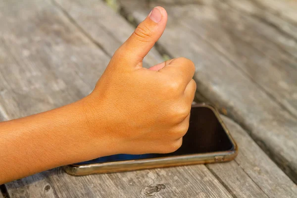 Çocuk başparmağı akıllı telefonlara izin veriyor. Yeni teknolojiler. Yazın ahşap masa