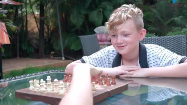 O rapaz está a jogar xadrez — Vídeo de Stock