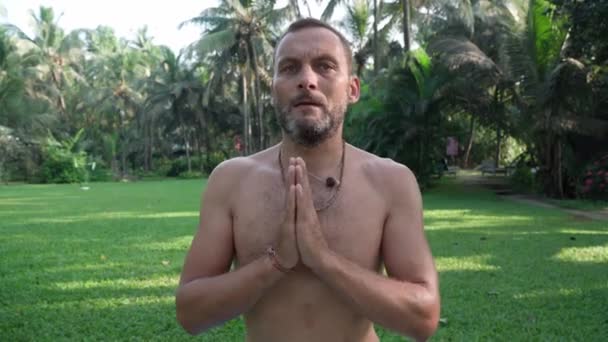 Yoga performing assanas in the morning in the park by a european man — Stockvideo